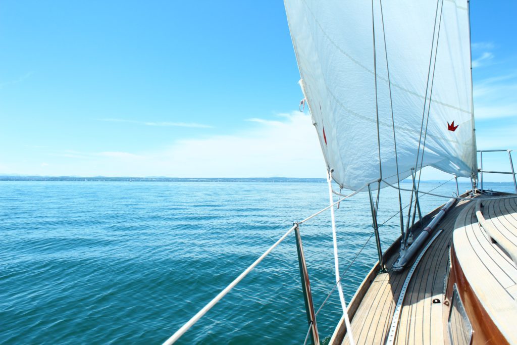 View from the left side of a wooden boat towards the ocean on a sunny day